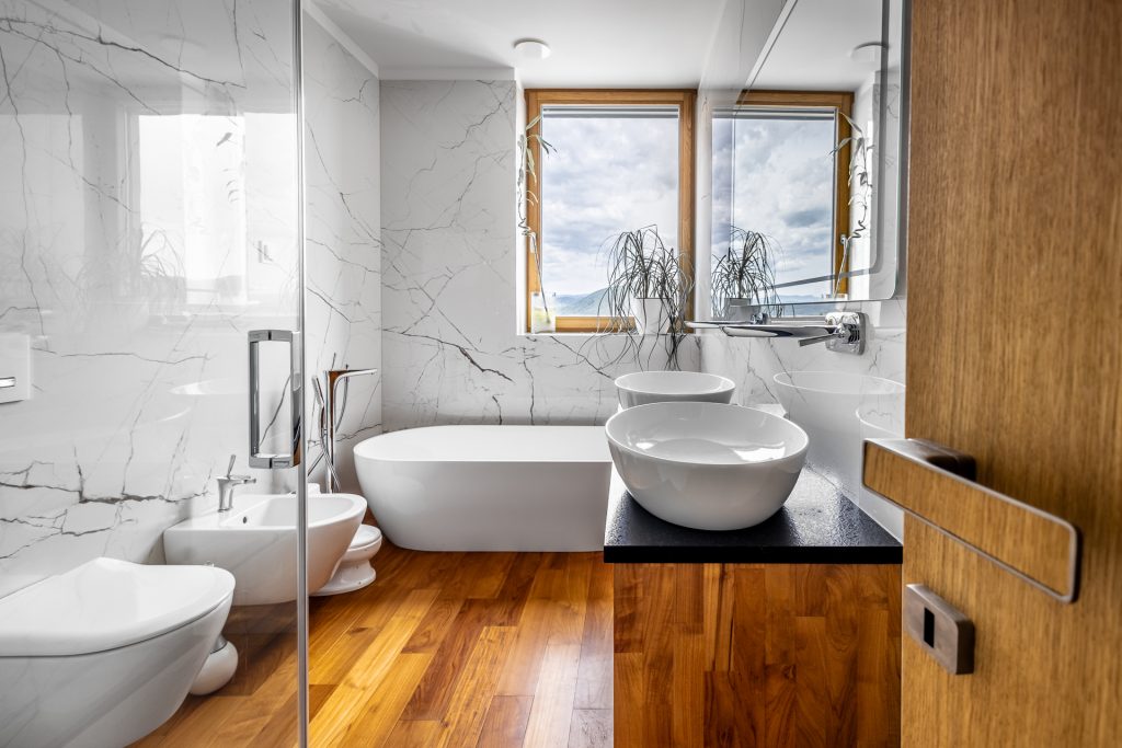 moderný interiér kúpeľne s teakovou podlahou a exkluzívnym vybavením - vaňa, umývadlá, bidet a pod.